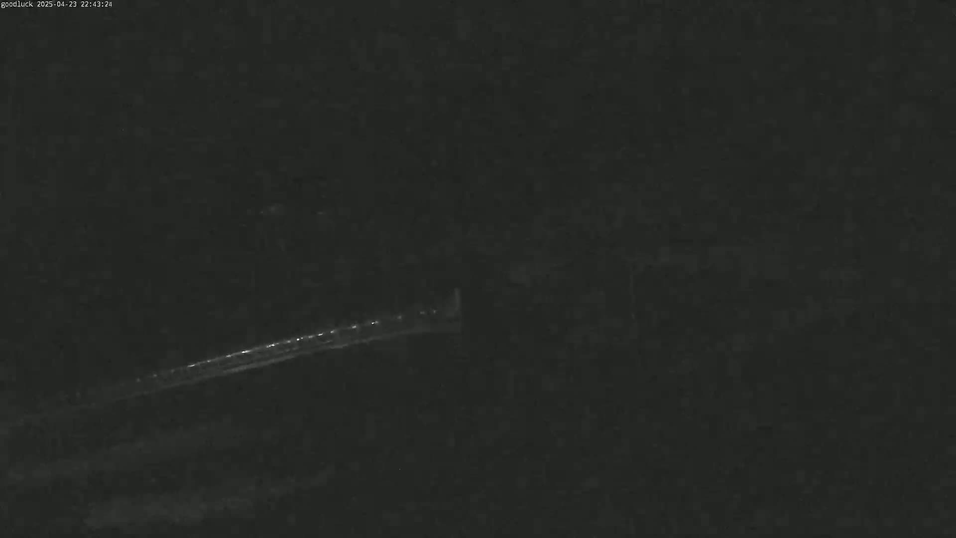 A long, thin streak of light is visible against a dark, nighttime sky.