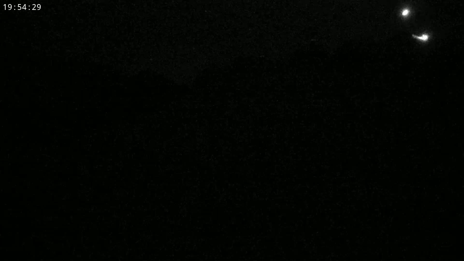 A dark, nighttime scene is visible with faint, distant lights.