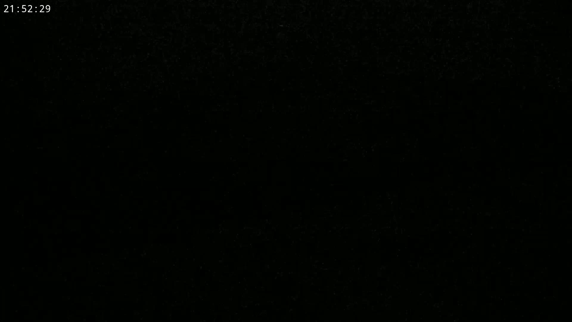 The image is a completely black screen with a few specks of lighter color.