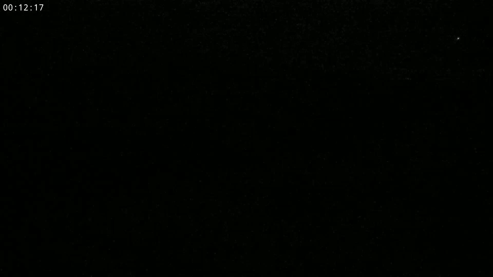 The image shows a dark, night sky with a few faint stars visible.
