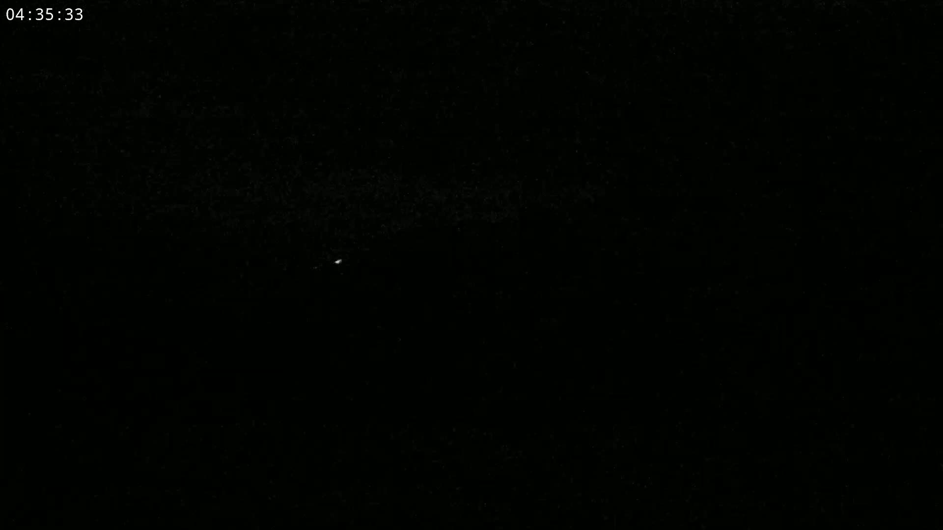 A single, faint light is visible in the dark night sky.