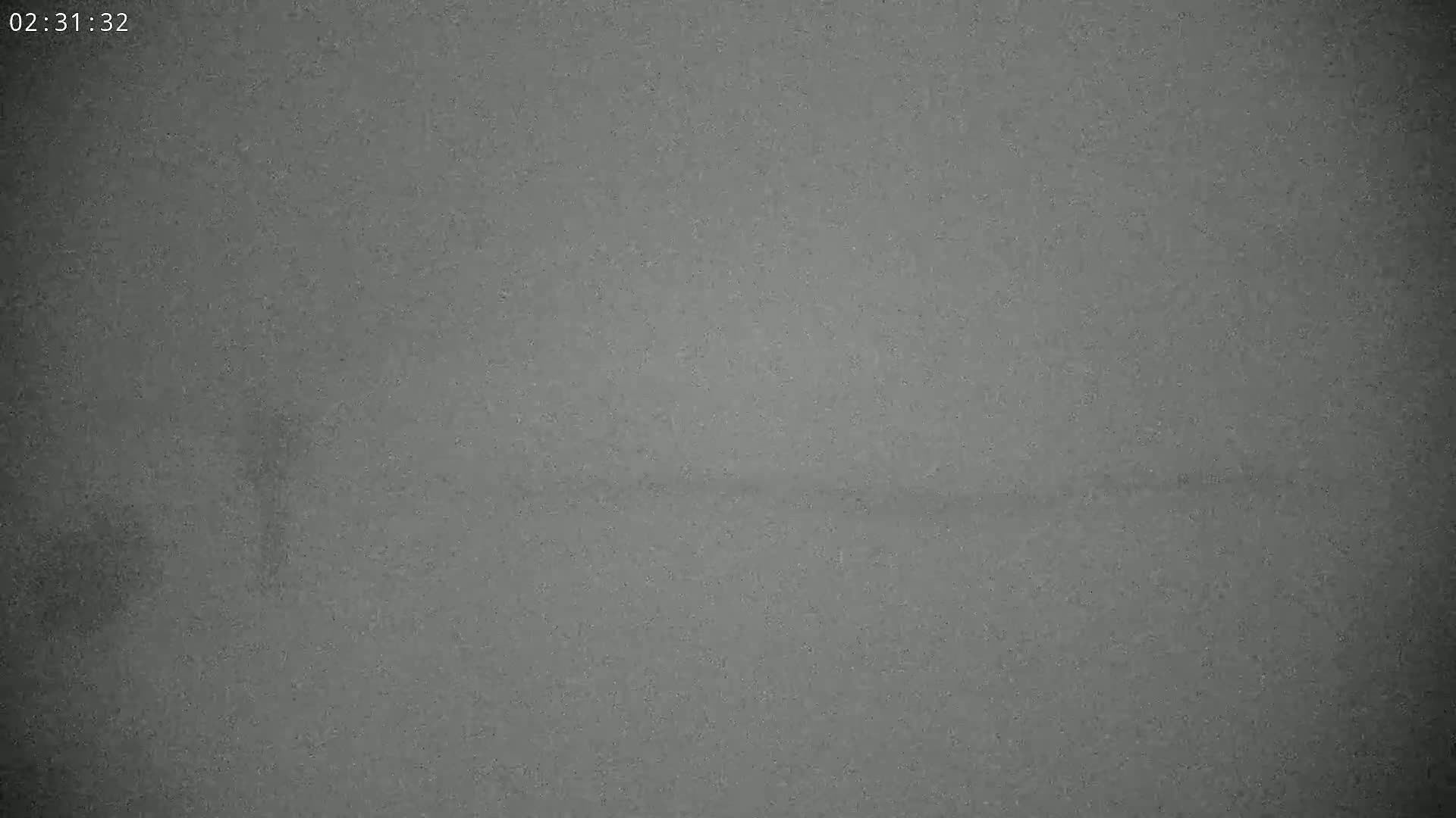 A grainy, dark gray image shows a mostly featureless expanse.