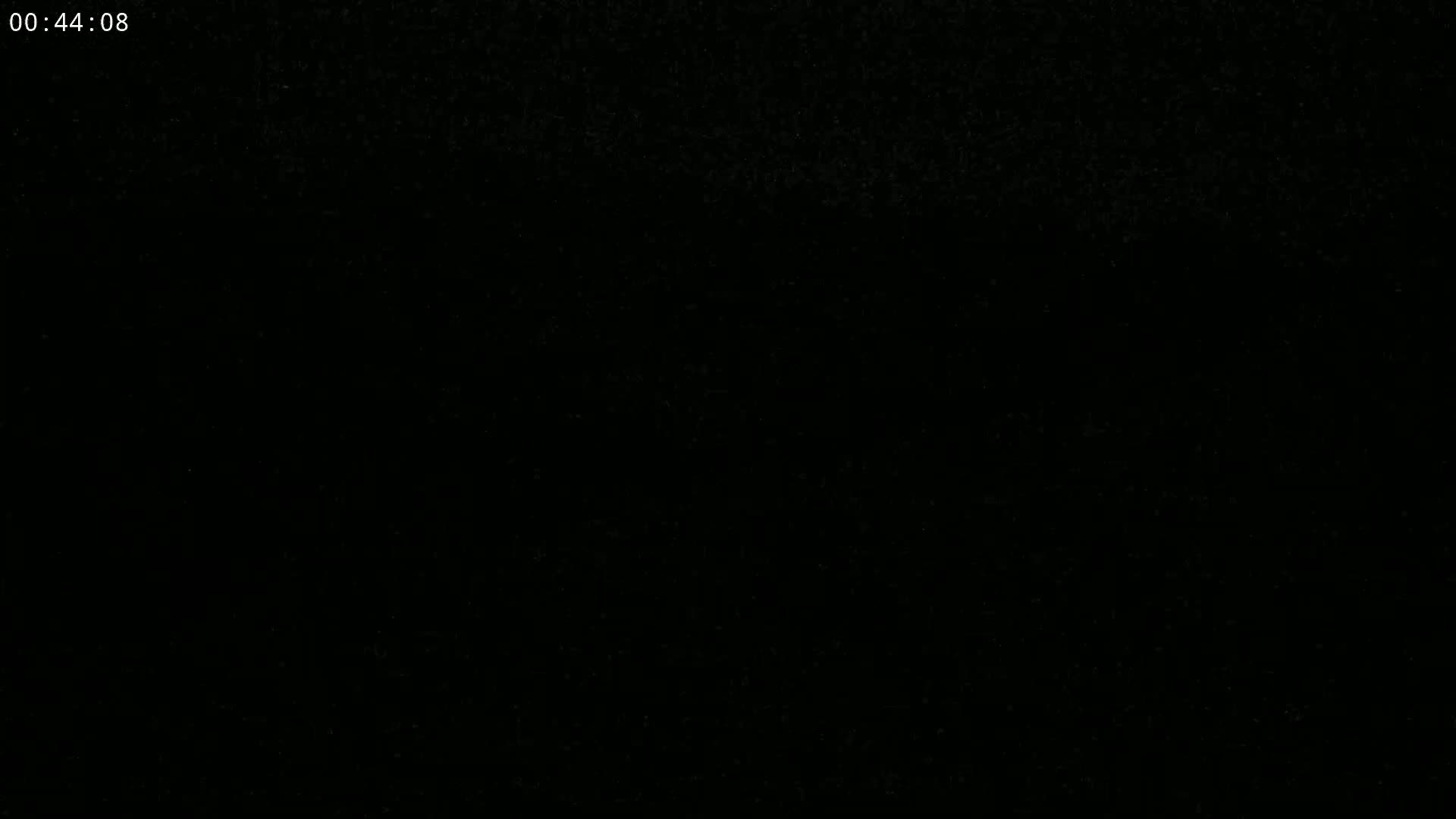 The image is a completely black screen with a few tiny specks of lighter color.