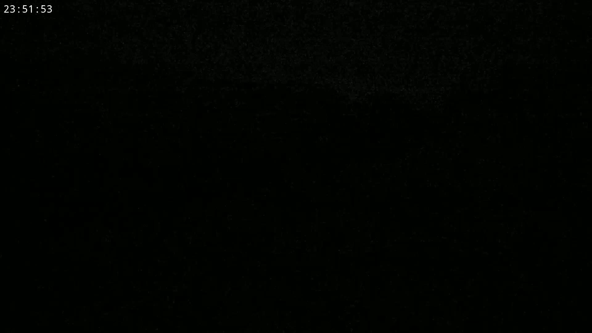A completely dark image with a few specks of light.