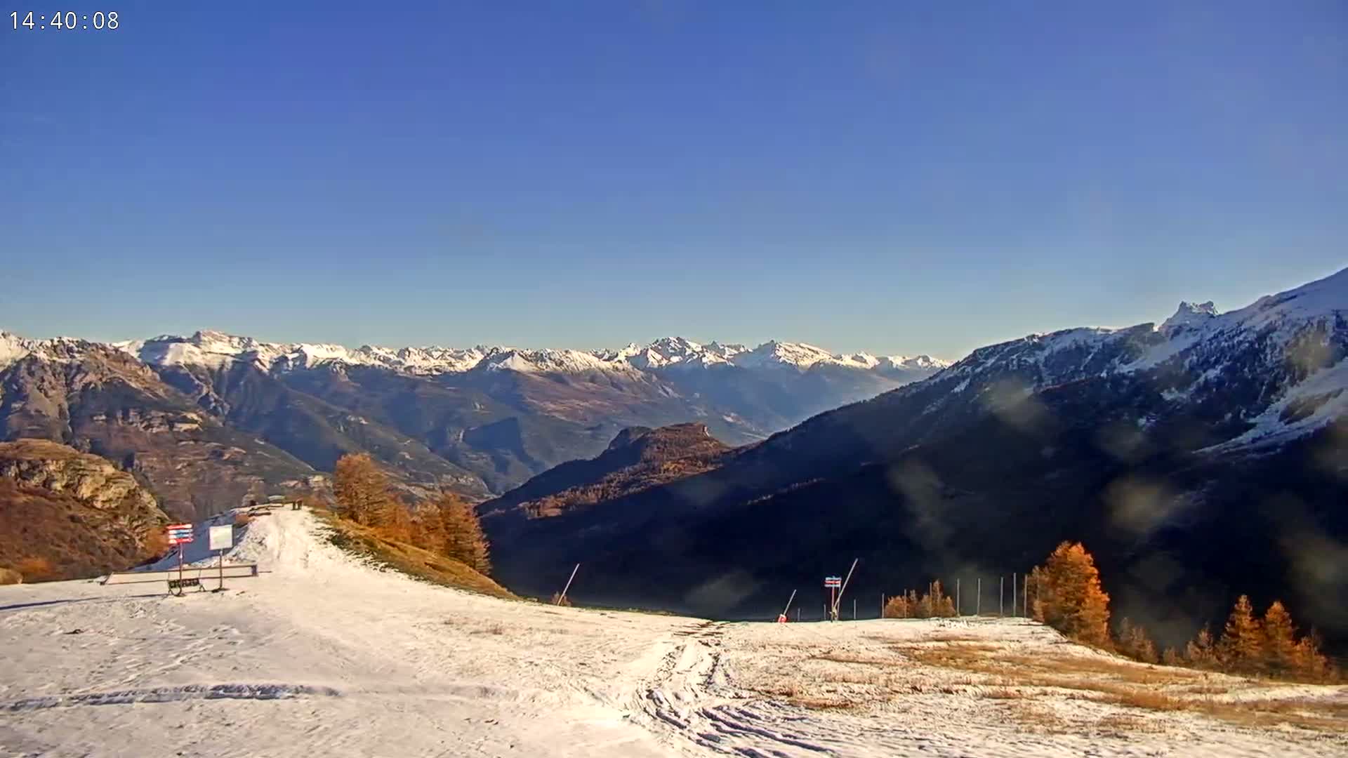 A bright moon shines in a twilight sky over dark, rolling hills and a dirt road.