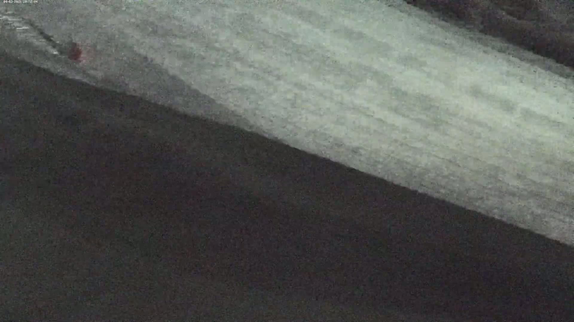 A dark-colored surface is angled against a lighter-colored, textured surface, possibly under overcast conditions.