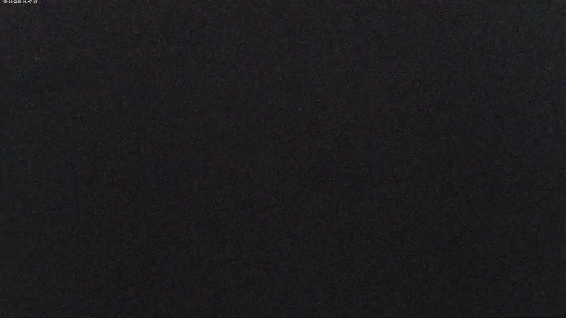 The image shows a completely dark, grainy surface.
