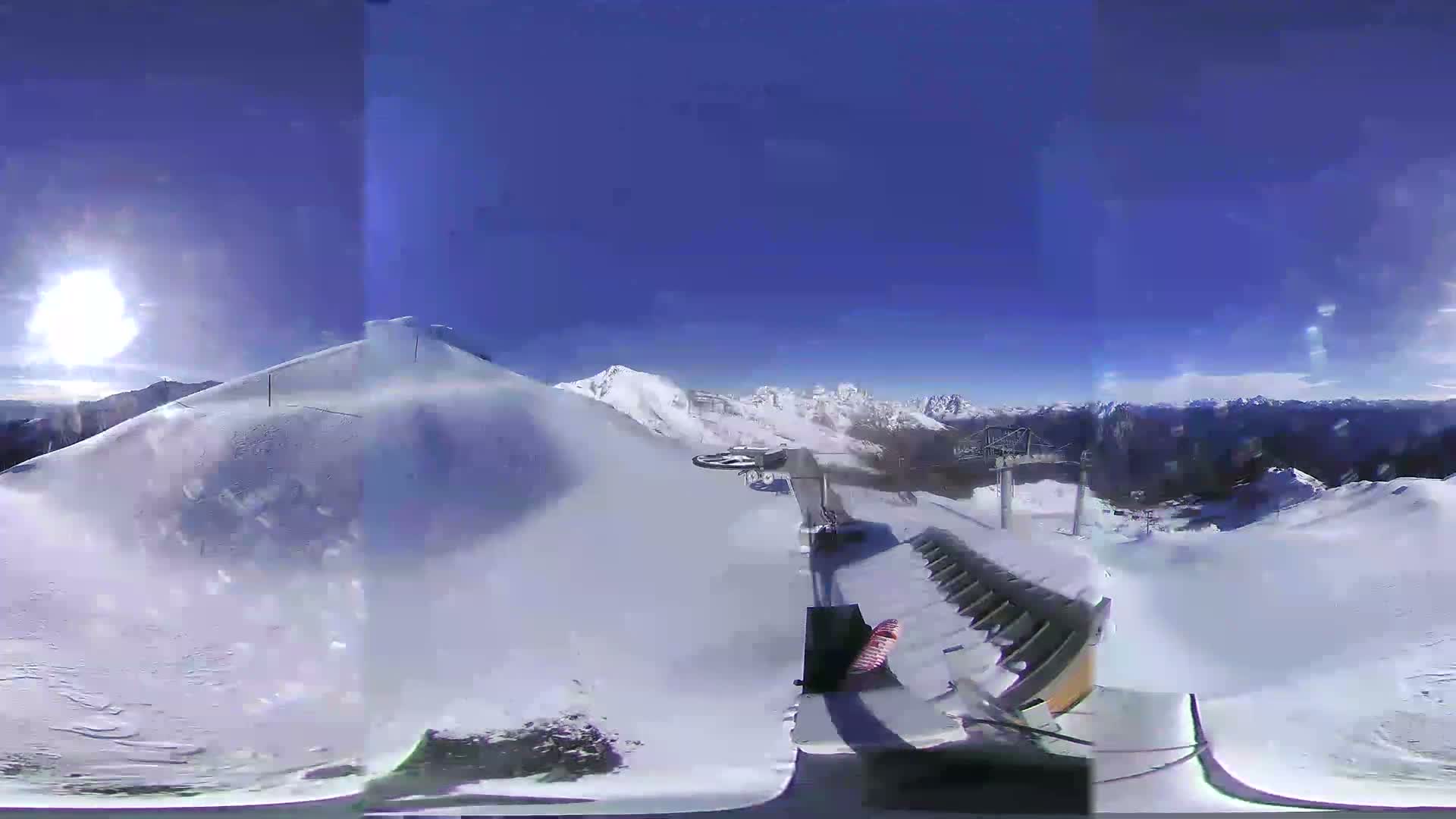 A snowy mountaintop scene with foggy weather shows a ski lift and a snow-covered slope.
