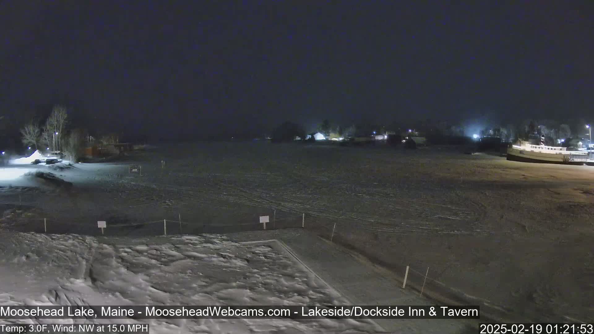 A snow-covered lakeside area at night with a northwest wind at 15 mph and a temperature of 3 degrees Fahrenheit.