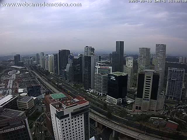 A cityscape of numerous high-rise buildings under a cloudy sky, with a wide highway visible in the foreground.