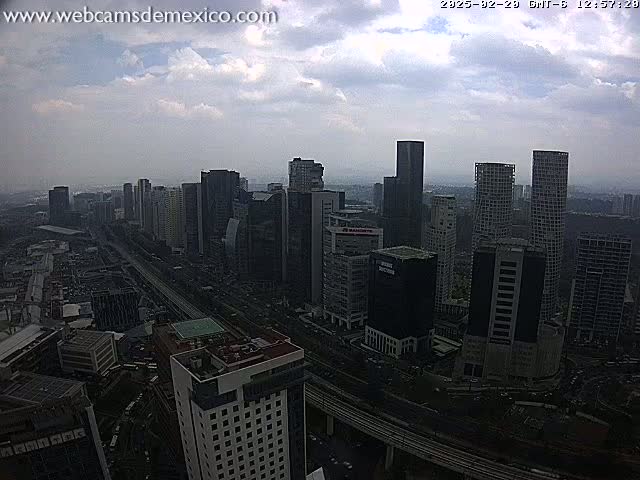 A high-angle, long shot of a city skyline on an overcast day, showing many tall buildings and a highway below.