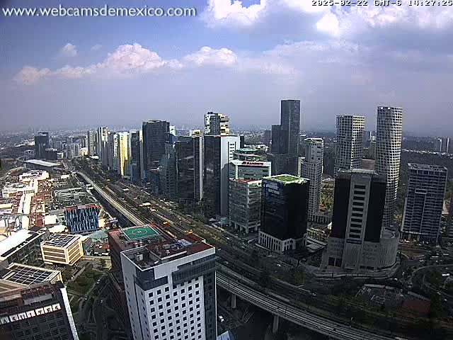 A partly cloudy day reveals a cityscape of numerous skyscrapers and high-rise buildings, with a highway weaving through the urban landscape.