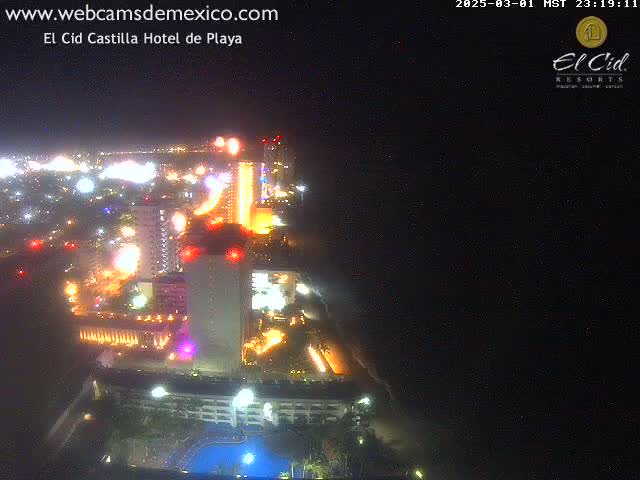 A brightly lit hotel complex and surrounding city at night, seen from an elevated perspective.
