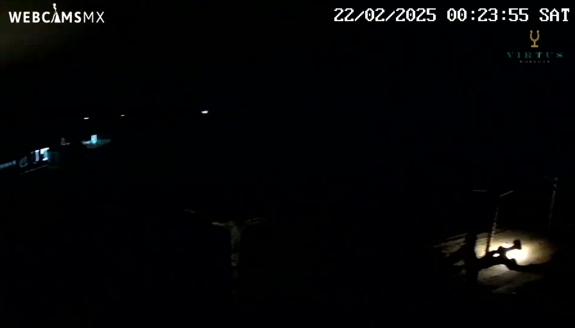 A dark, nighttime scene shows a dimly lit area with a figure illuminated by a light source in the lower right corner.