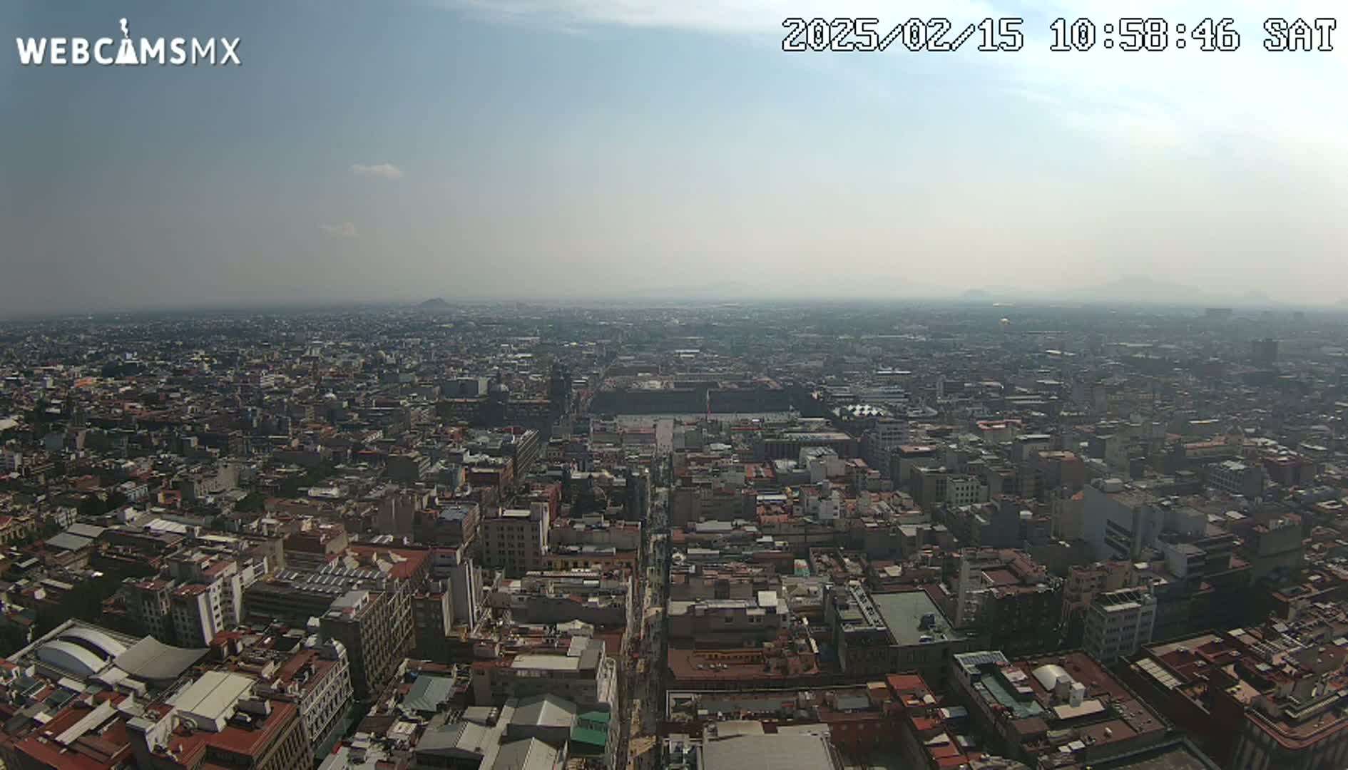A hazy, sunny day reveals a sprawling cityscape stretching to the horizon.