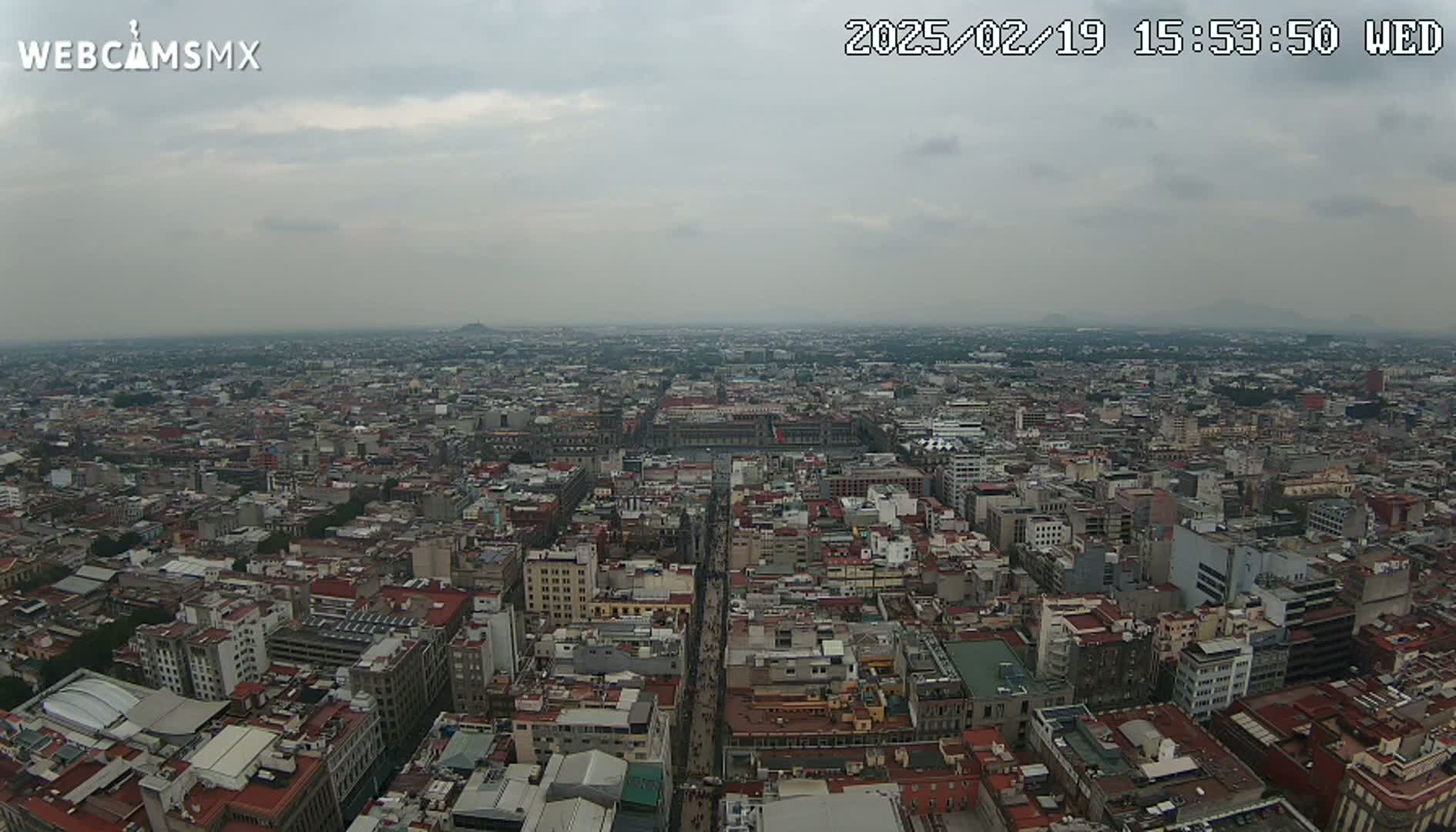 A high-angle, long shot of a sprawling city under an overcast sky.