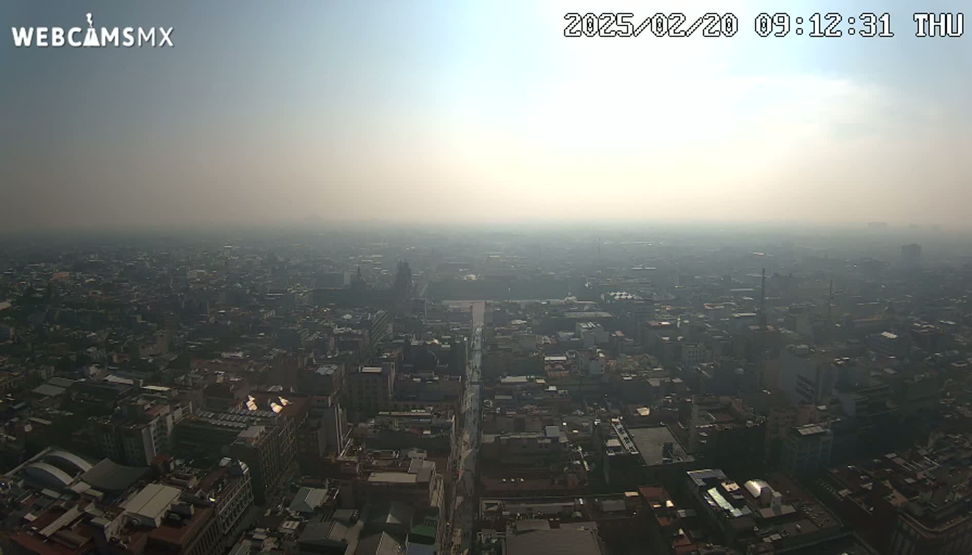 A hazy, high-angle view of a sprawling city on a clear, but smoggy day.