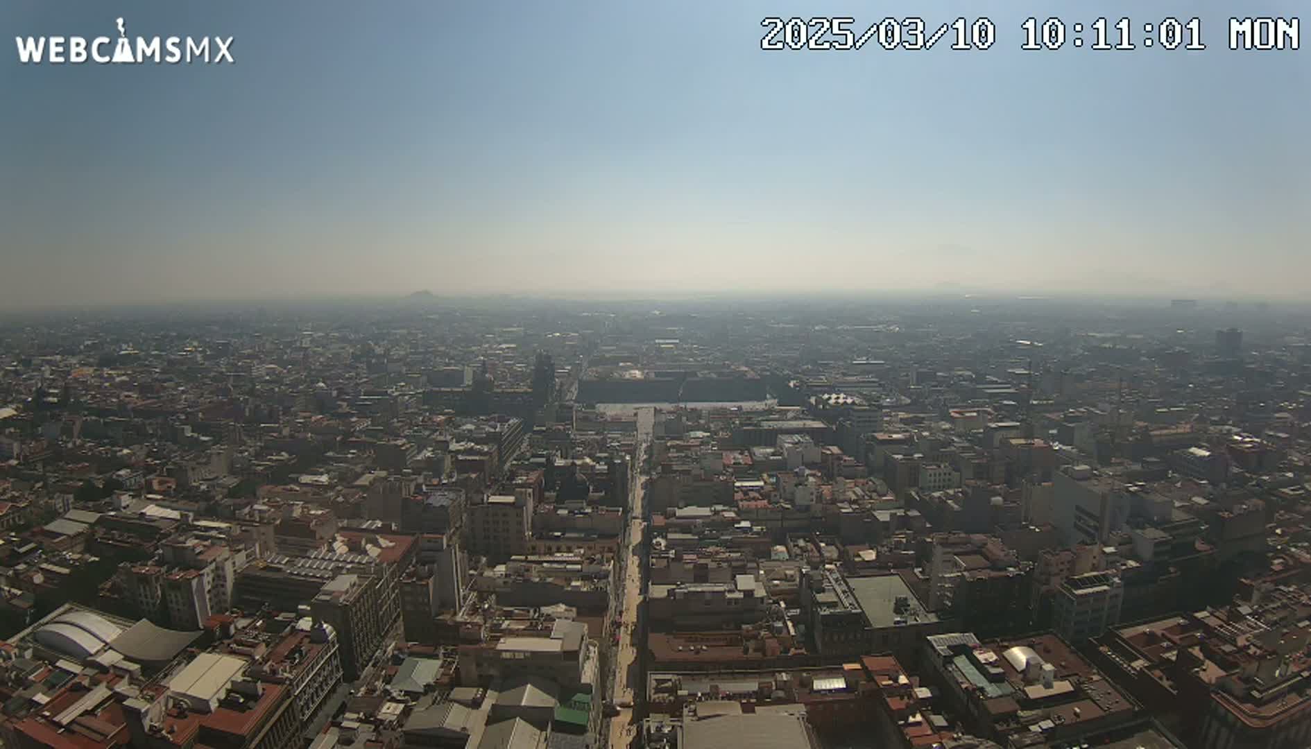 A hazy, sunny day reveals a sprawling cityscape extending to the horizon.