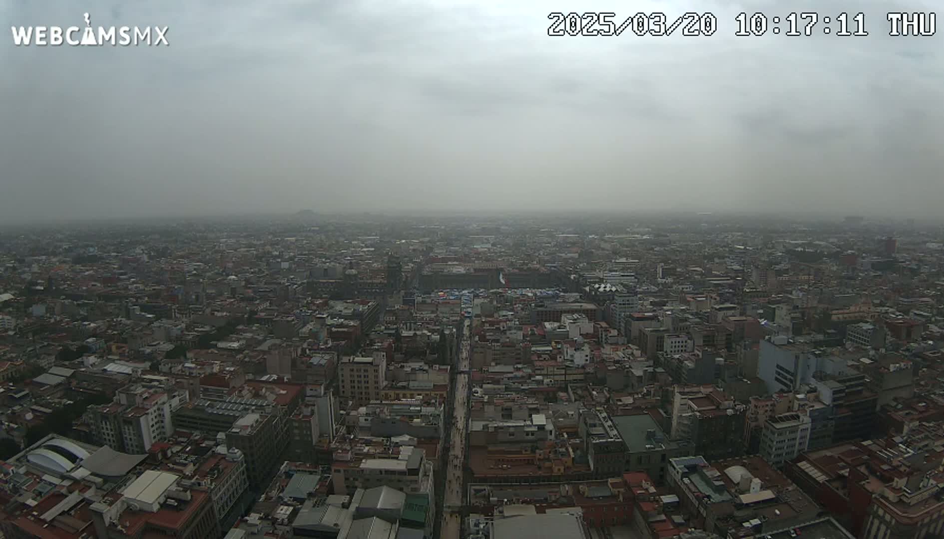 A hazy, overcast day reveals a sprawling cityscape stretching to the horizon.