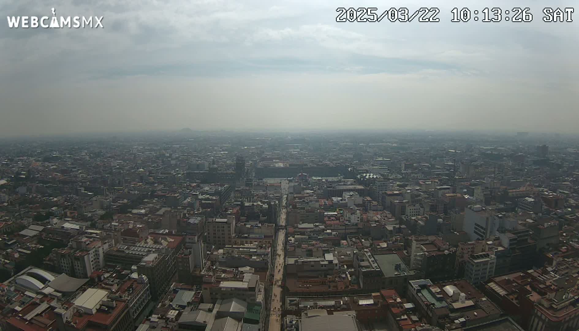 A hazy, overcast day reveals a sprawling cityscape extending to the horizon.