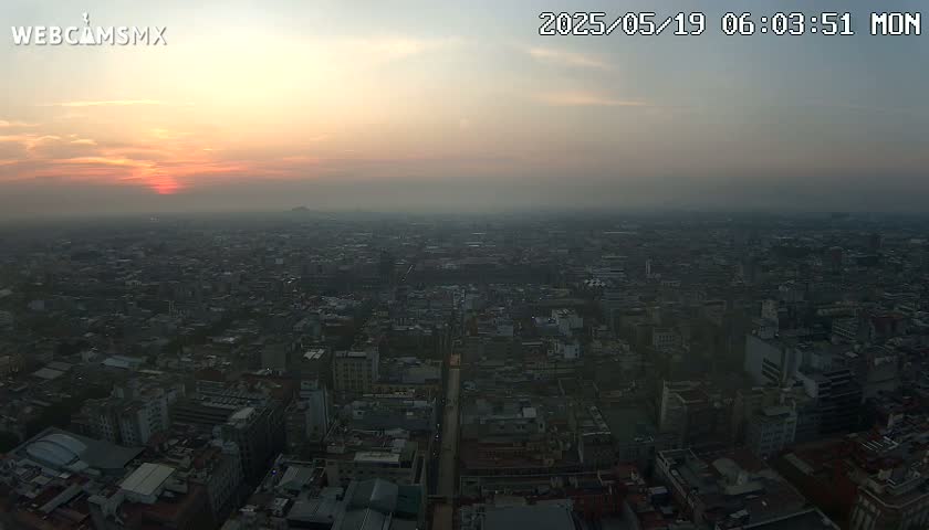 A hazy sunset over a vast, sprawling city.