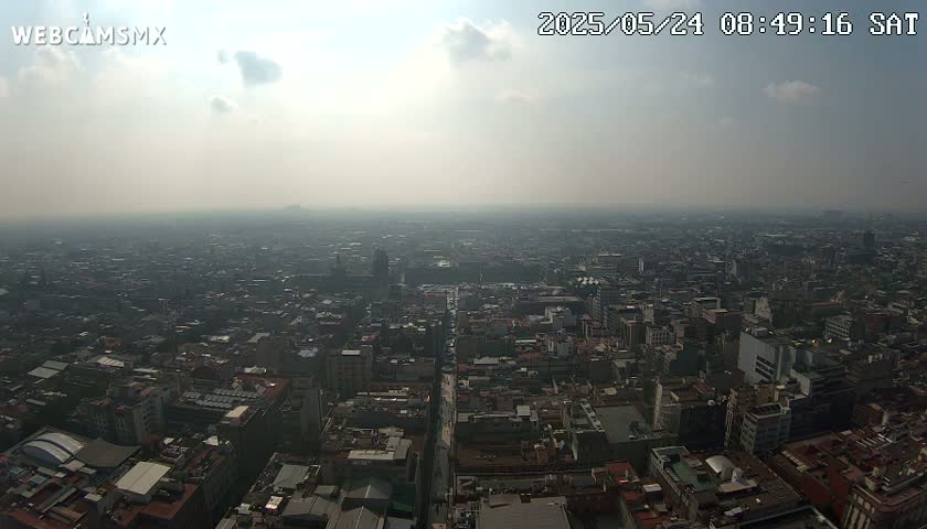 A hazy, sunny day reveals a sprawling cityscape extending to the horizon.