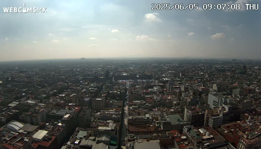 A hazy, sunny day reveals a sprawling cityscape stretching to the horizon.