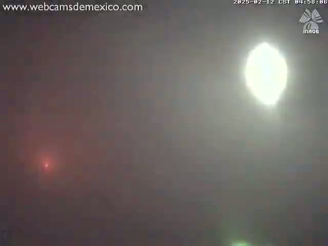 A hazy, bright sun is visible in the sky, with a faint reddish glow near the bottom of the frame.