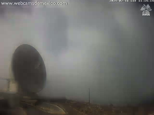 A large satellite dish is partially visible through a thick fog.