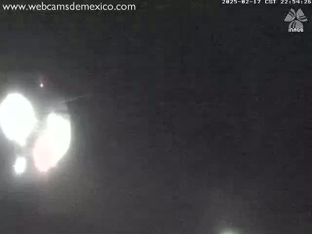 Bright lights are visible in a dark, nighttime sky.