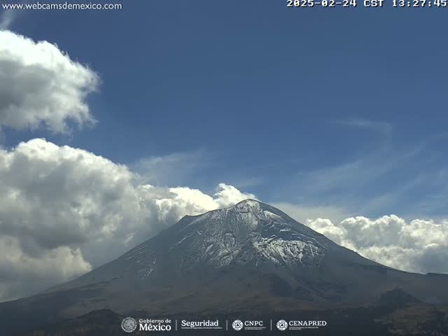 A snow-capped mountain is visible under a partly cloudy sky.