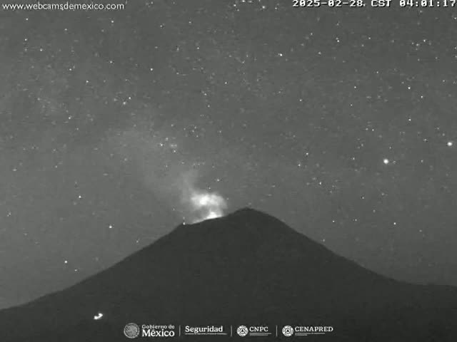 A volcano erupts under a clear, starry night sky.
