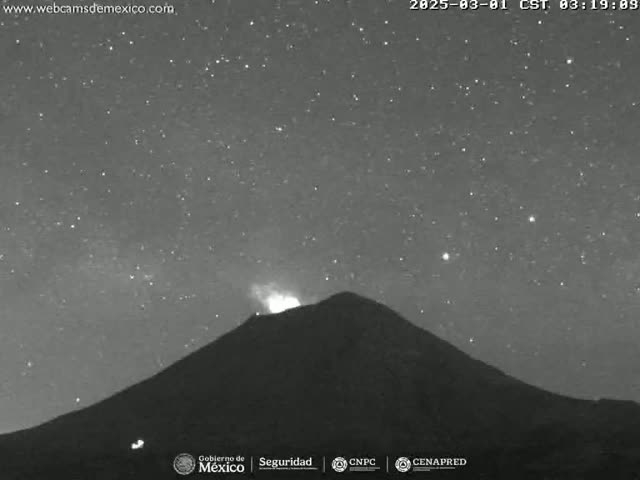 A volcano erupts under a clear, starry night sky.