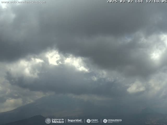 A mostly cloudy sky hangs over a mountain range under overcast conditions.