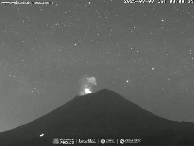 A dark, starlit night shows a volcano with a small eruption at its peak.