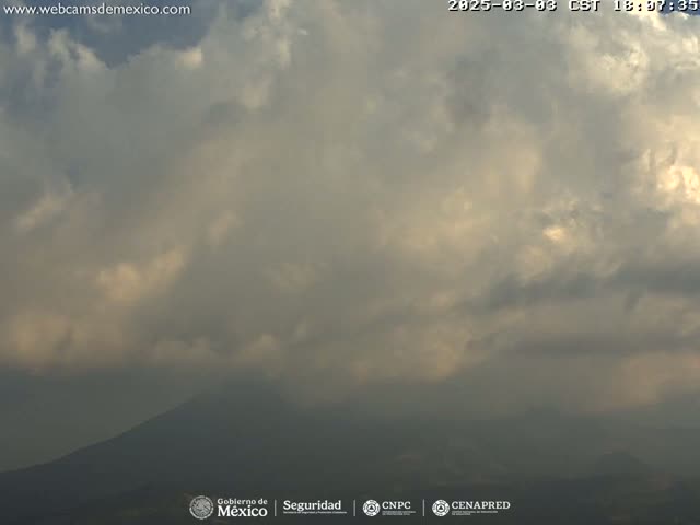 A partly cloudy sky obscures a distant mountain range.