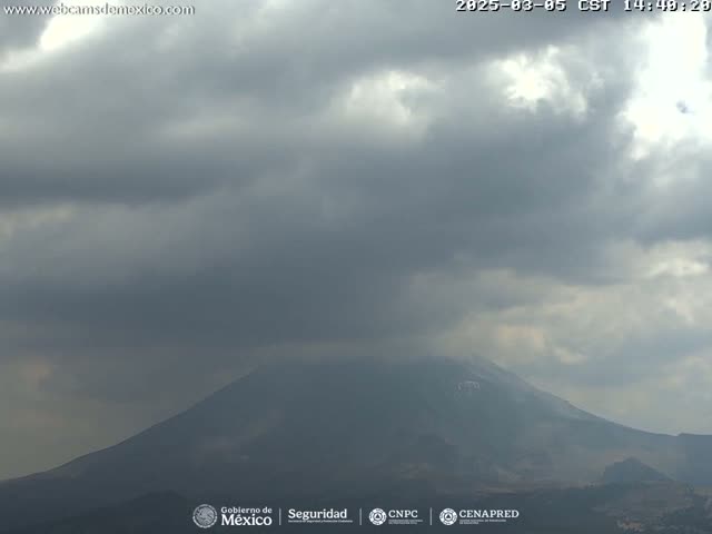 A large, dark mountain is partially obscured by an overcast sky.
