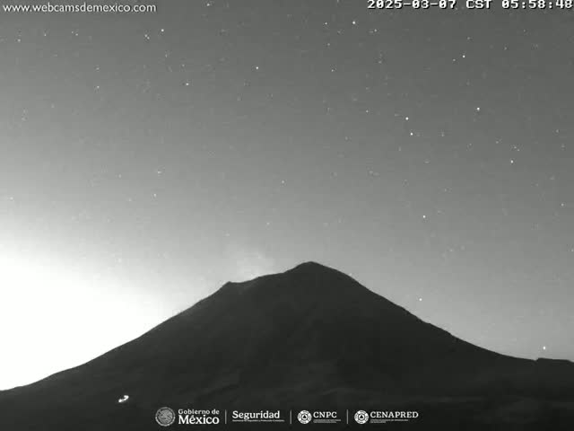 A dark, silhouetted volcano is visible under a night sky filled with stars.