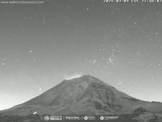 A large, dark mountain is visible under a clear, starry night sky.