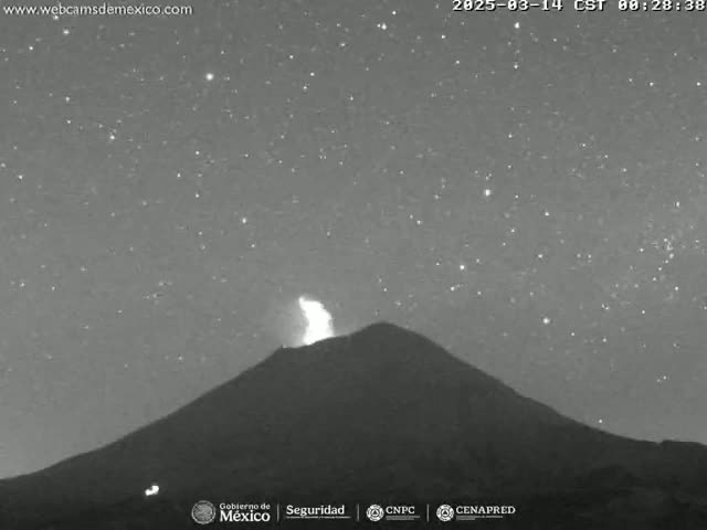 Under a clear, starry night sky, a volcano erupts with a plume of ash rising into the air.