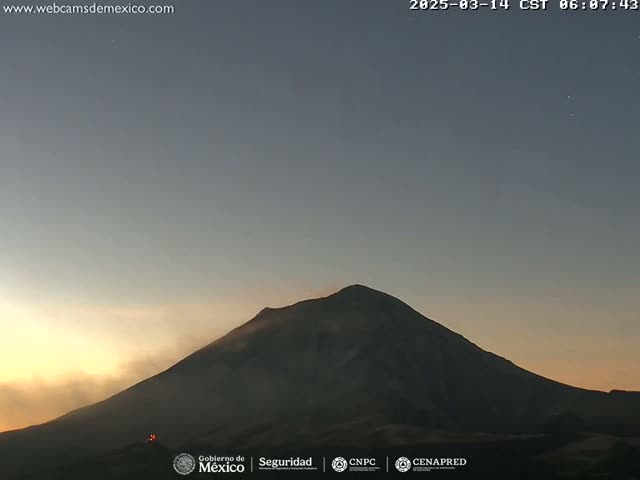 A dark, silhouetted volcano is visible against a twilight sky.