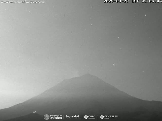 A grayscale image shows a large, dark mountain under a night sky dotted with stars.