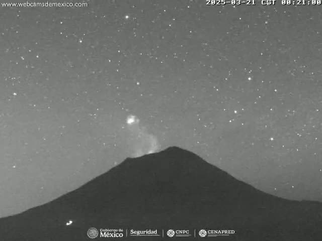 A volcano erupts under a clear, starry night sky.