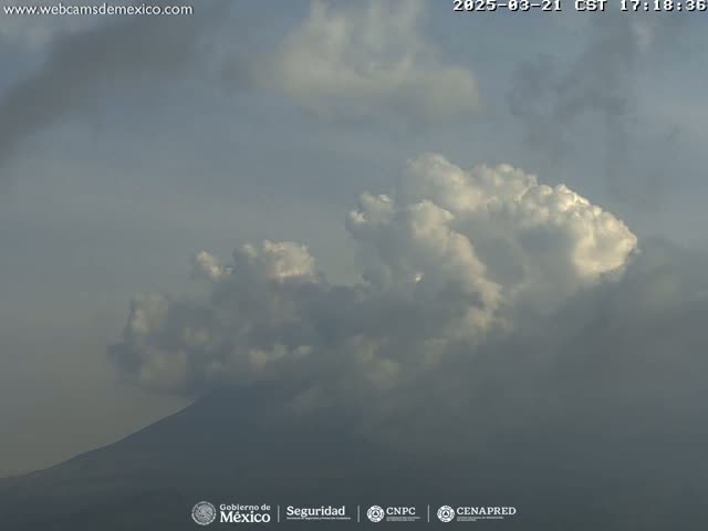 A partly cloudy sky obscures a distant mountain.