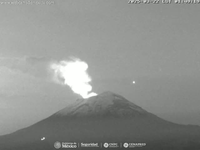 A grayscale image shows a volcano erupting a plume of smoke and ash under a twilight sky.