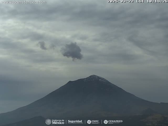 A snow-capped mountain is visible under a mostly cloudy sky.