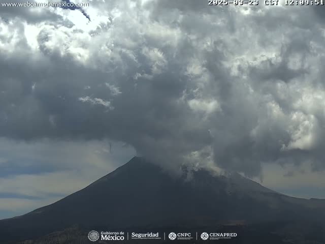 A dark, cloudy sky overhangs a large, dark mountain that appears to be emitting a plume of ash or smoke.
