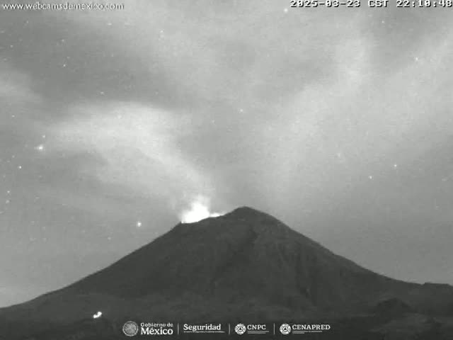 A grayscale image shows a volcano erupting under a night sky with some clouds.