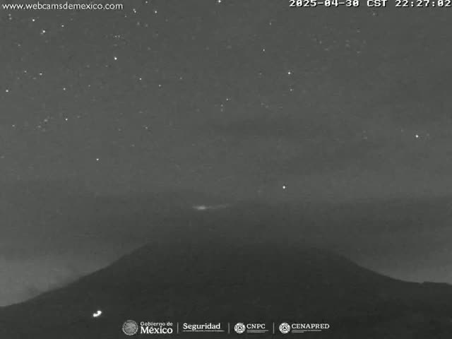 A nighttime long shot shows a dark mountain silhouetted against a starry sky with a faint glow near the horizon.