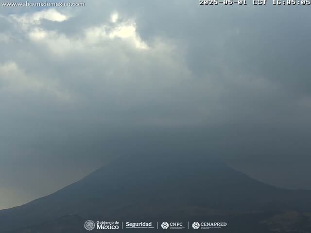 A hazy, overcast sky covers a dark, distant mountain.